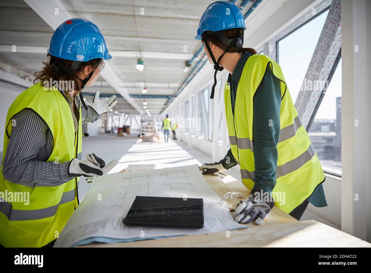 Female engineers planning over blueprint at construction site Stock Photo