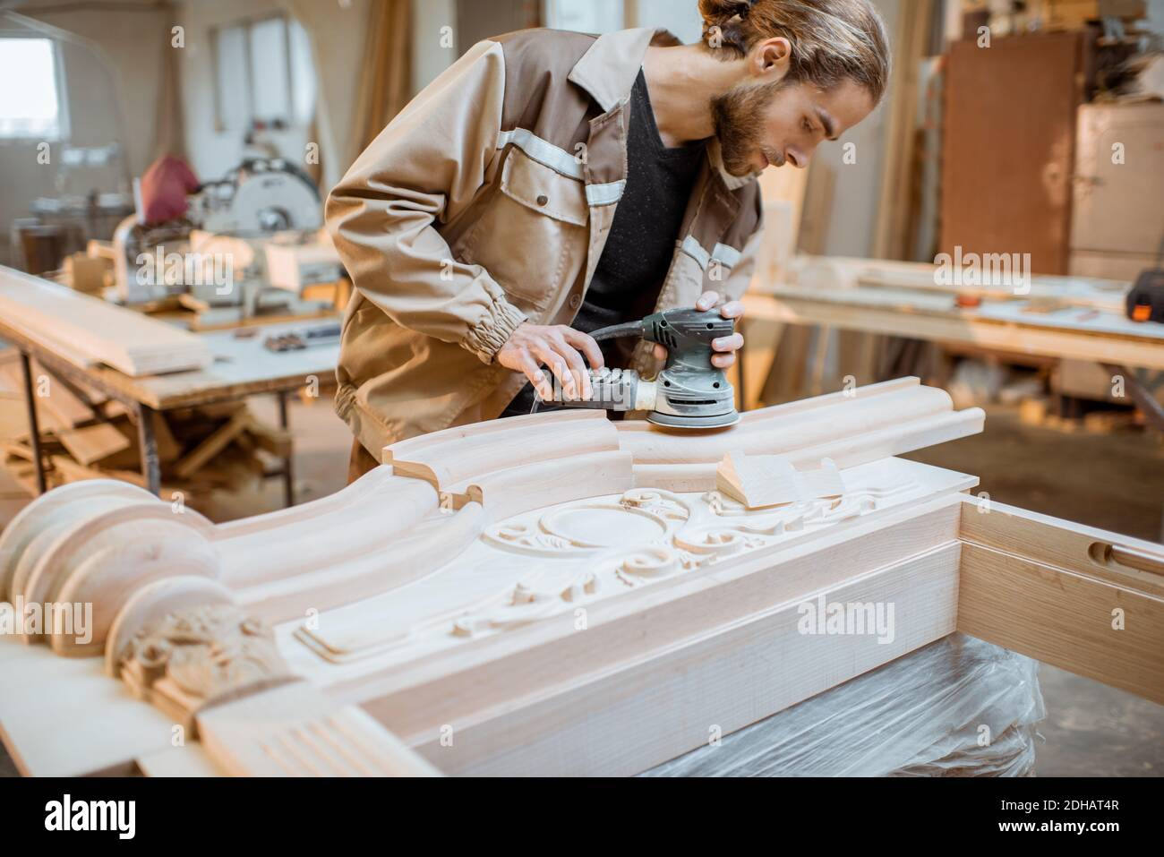 Carpenter grinding joinery product with carvings, finishing woodwork at