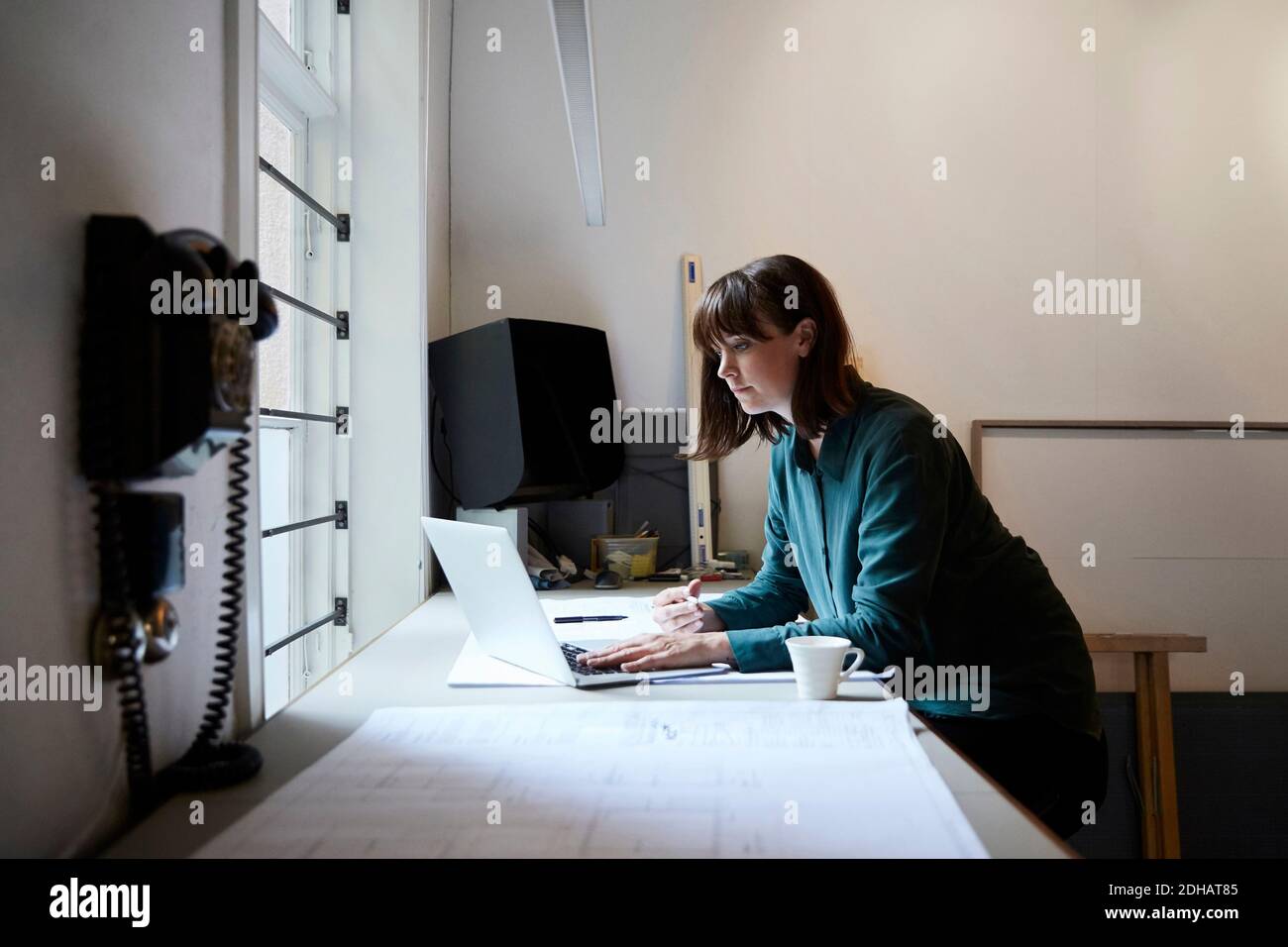 Confident female architect using laptop in office Stock Photo