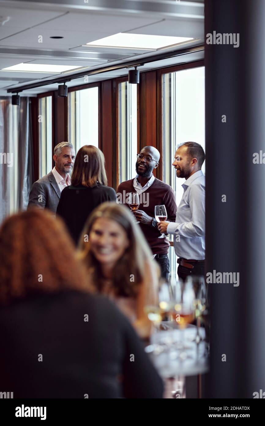 Professionals discussing over drinks at conference in office Stock Photo