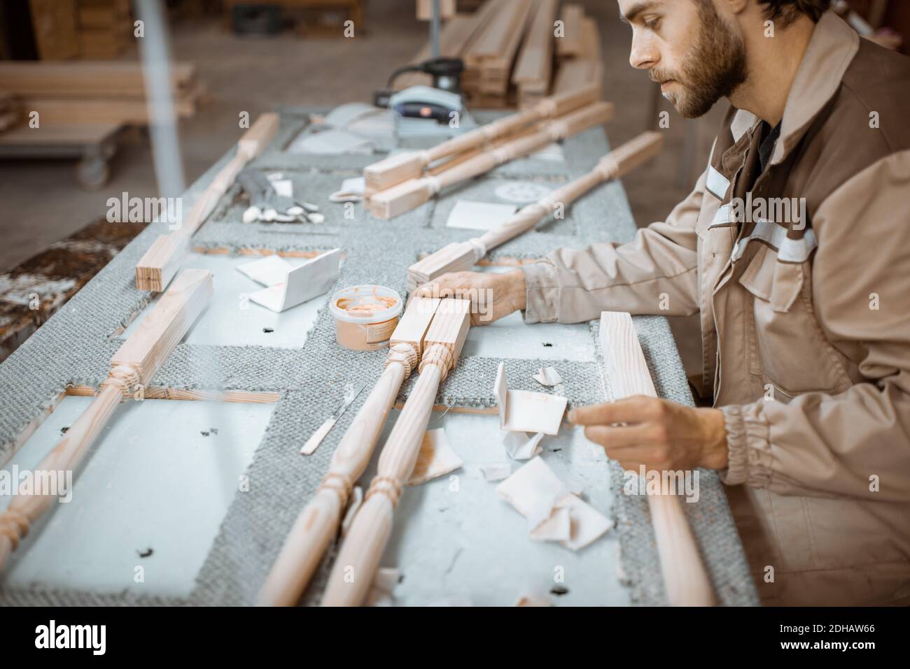 Manual worker finishing wooden products, spackling and grinding