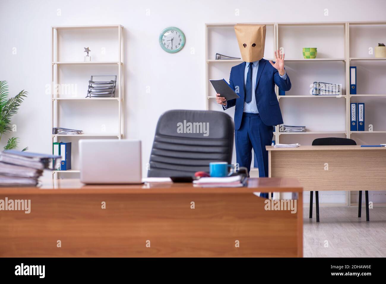 Young male employee with box instead of his head Stock Photo