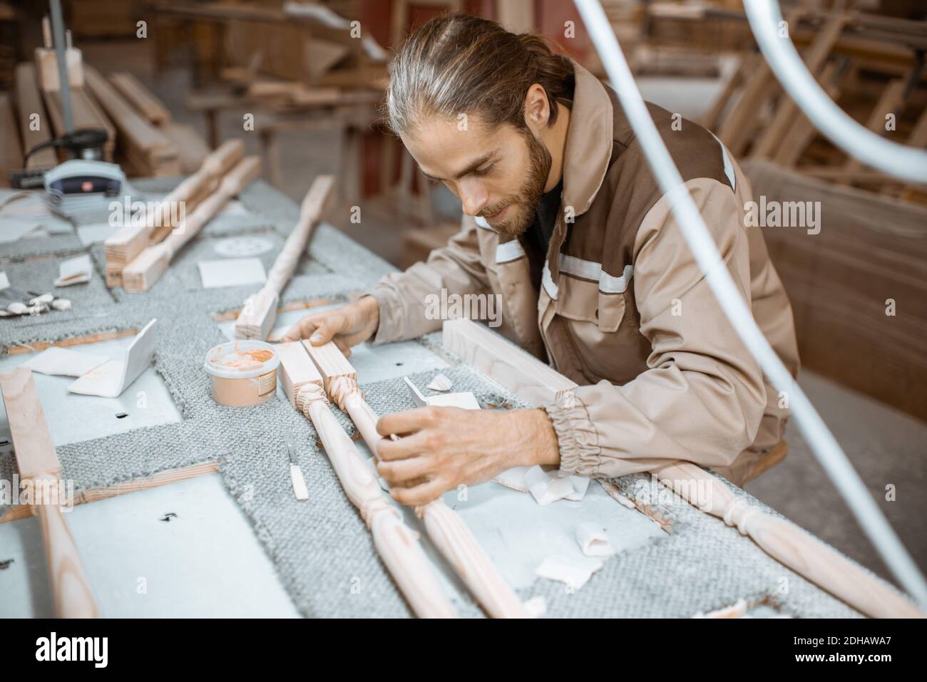Manual worker finishing wooden products, spackling and grinding