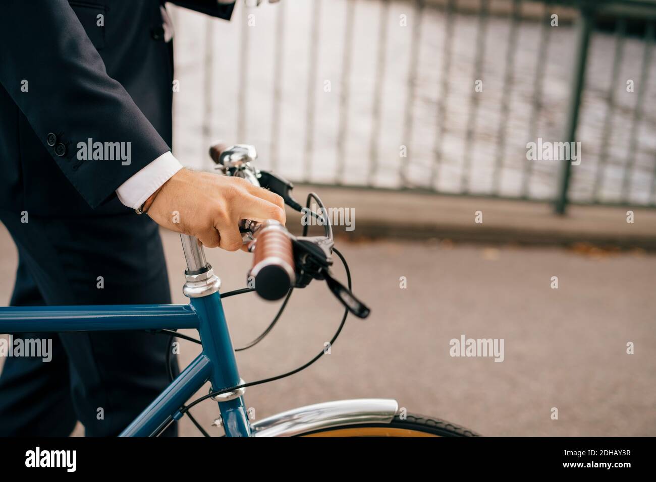 Midsection of businessman with bicycle on bridge in city Stock Photo