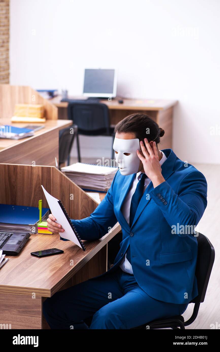Young male employee wearing mask in the office Stock Photo