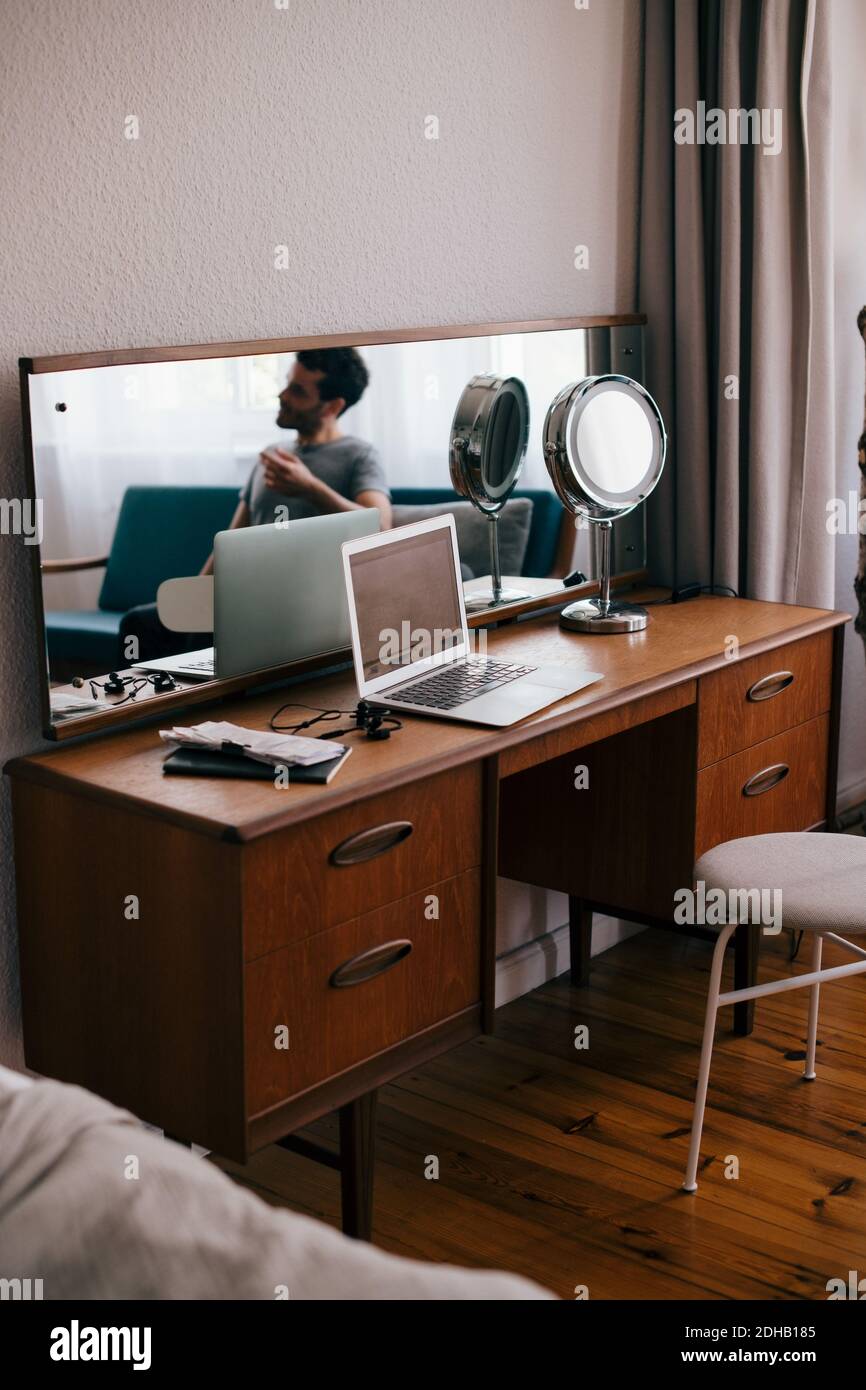 Mid adult man reflecting on mirror in bedroom Stock Photo - Alamy