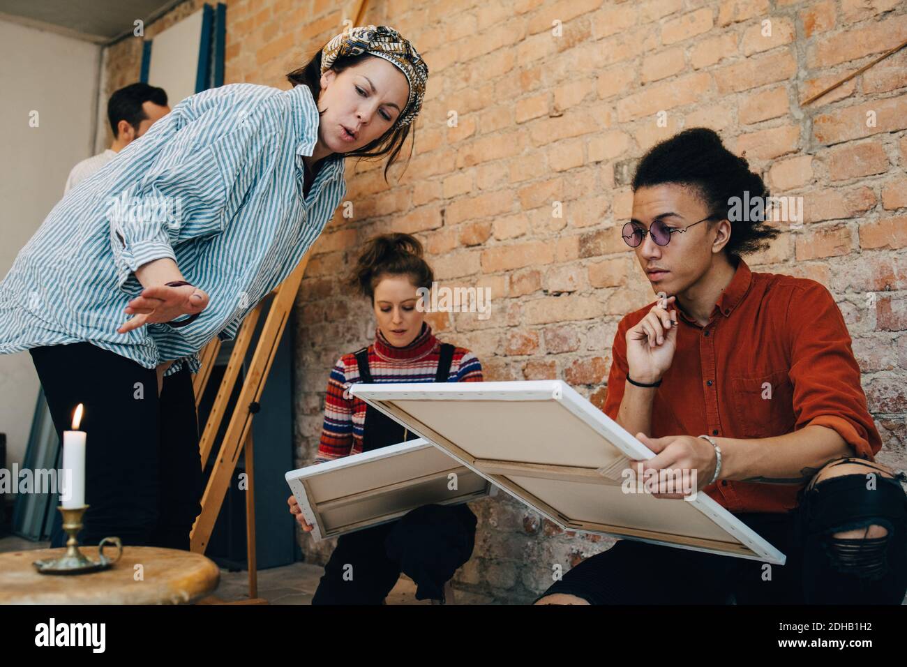 Instructor teaching artists with canvas at art studio Stock Photo