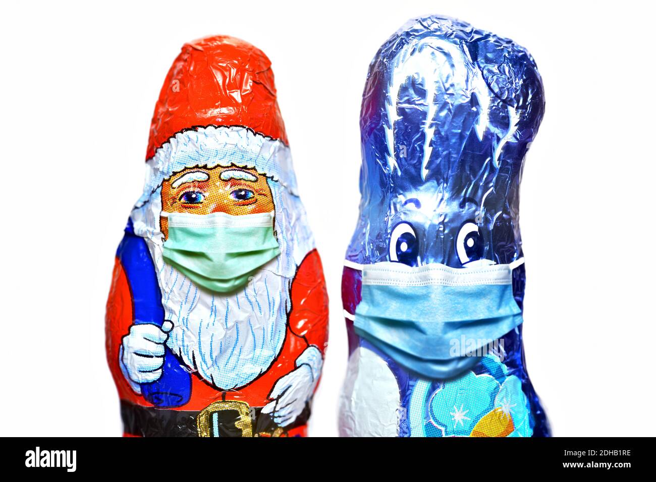 FOTOMONTAGE, Schoko-Weihnachtsmann und Schoko-Osterhase mit Schutzmaske, Weihnachtsfest zu Corona-Zeiten und Corona-Beschränkungen Stock Photo