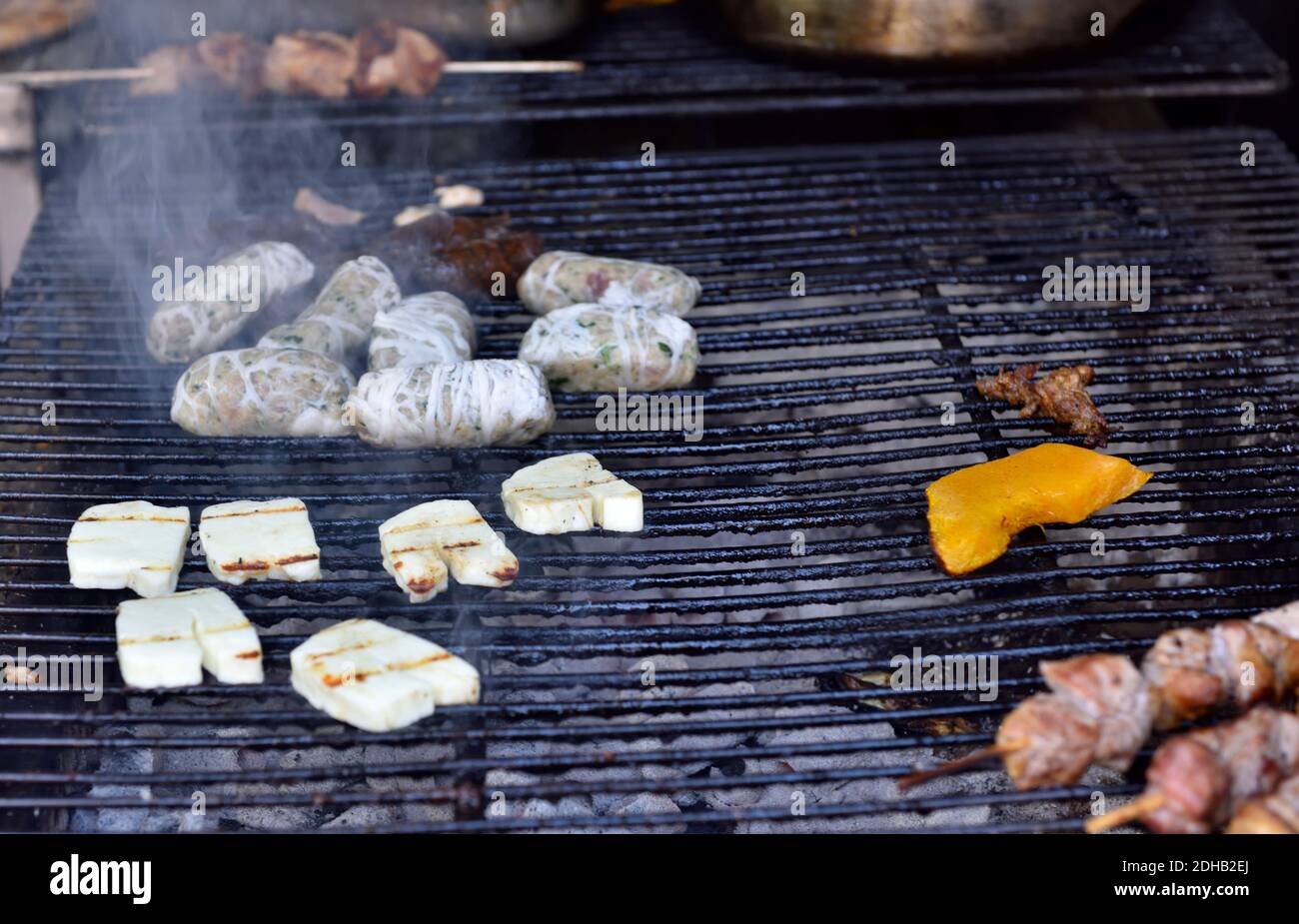Grill of charcoal bar-b-cue with sausages and halloumi cheese cooking Stock Photo