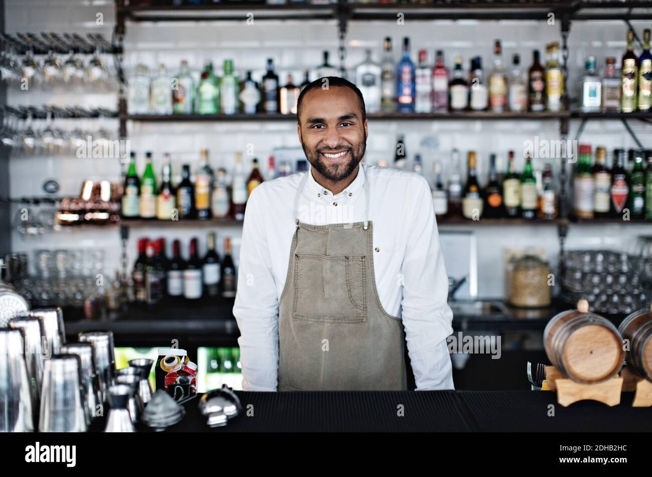 Portrait of smiling confident owner standing at checkout counter in restaurant Stock Photo