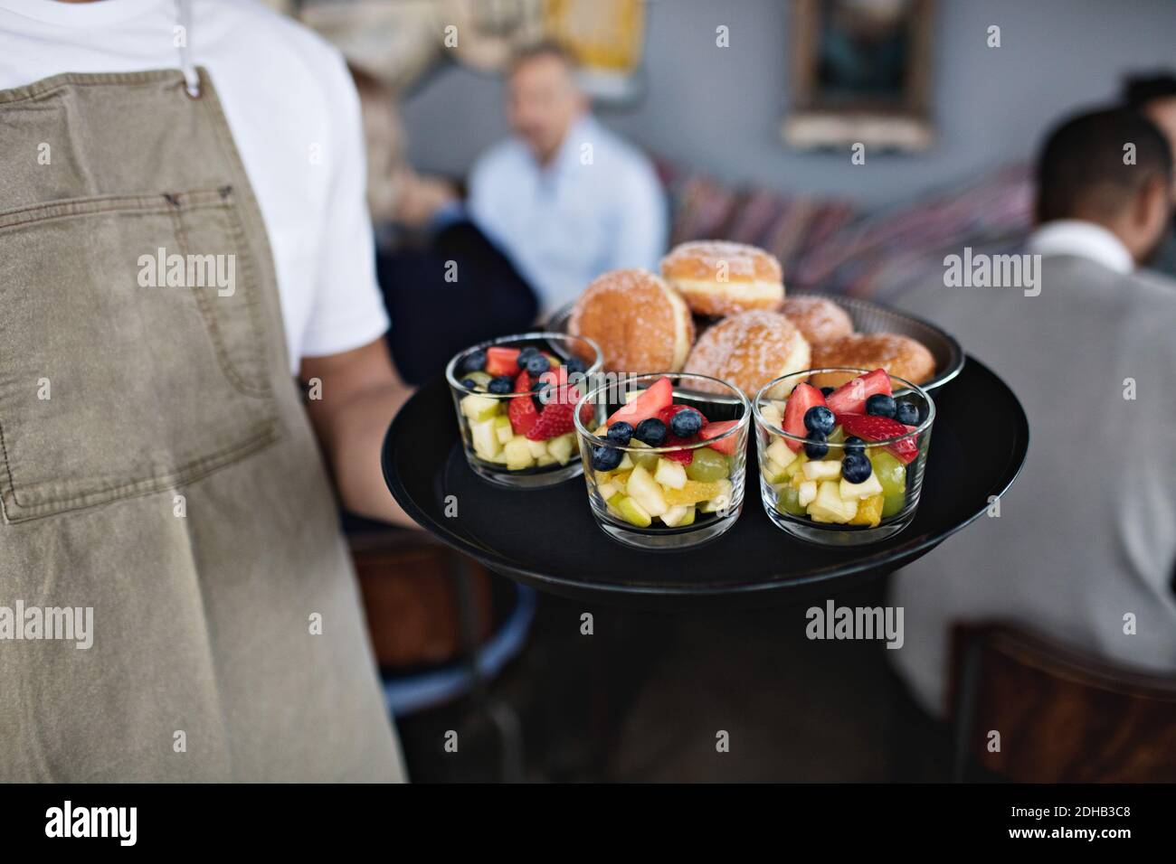 Midsection of owner holding food in serving tray at restaurant Stock Photo