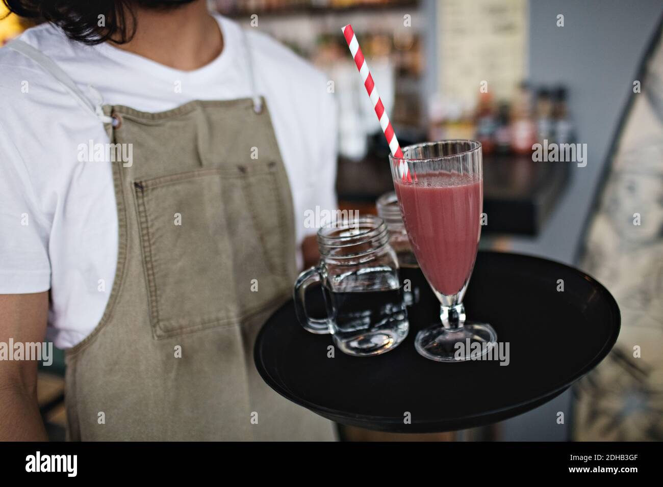 Midsection of owner holding drink in serving tray at restaurant Stock Photo