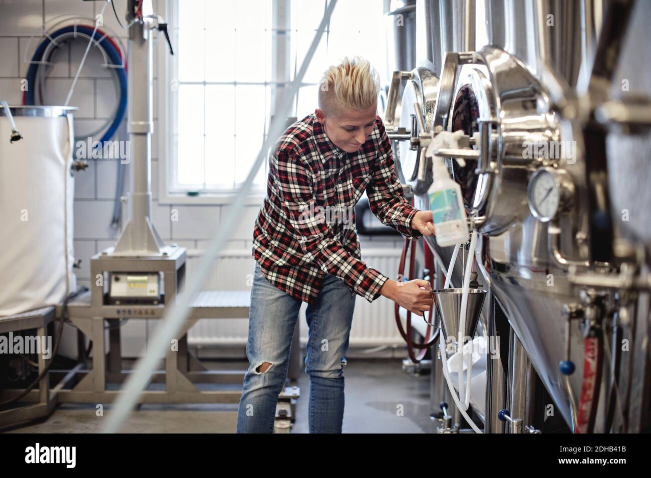 Female manager working by storage tank at brewery Stock Photo