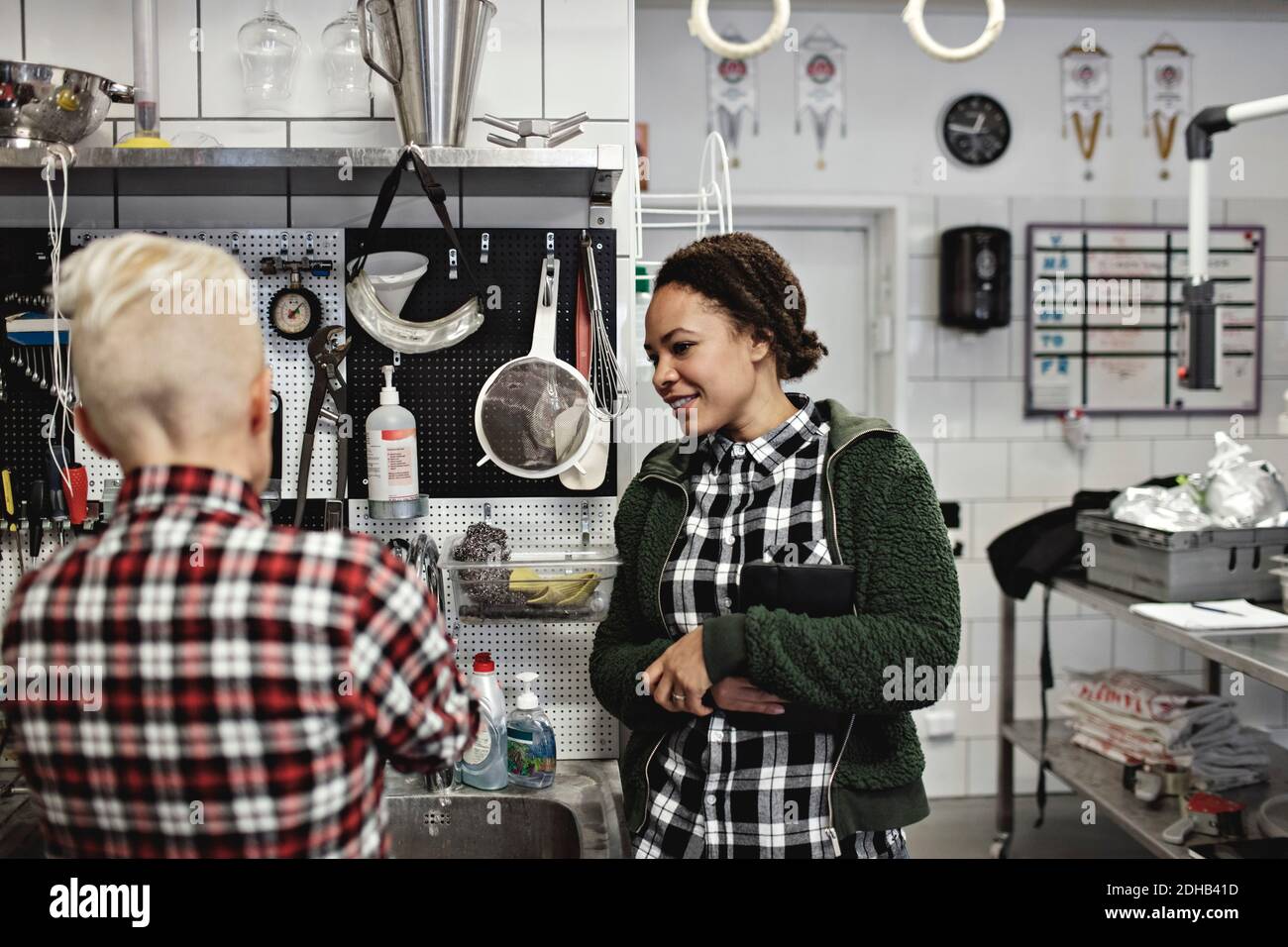Female workers discussing while working in brewery Stock Photo