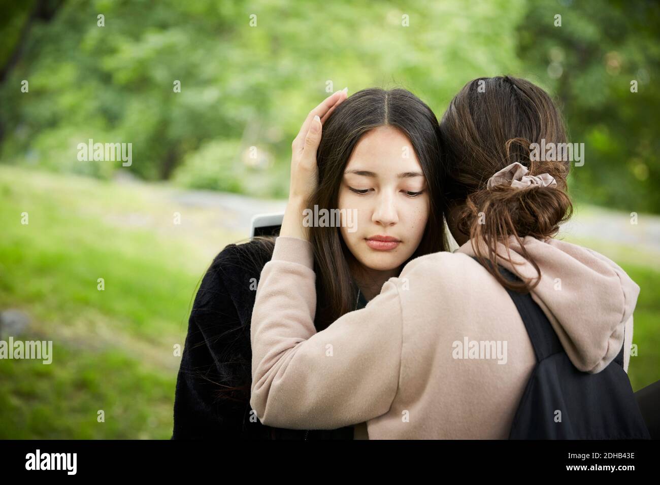 Teenage girl consoling female friend Stock Photo