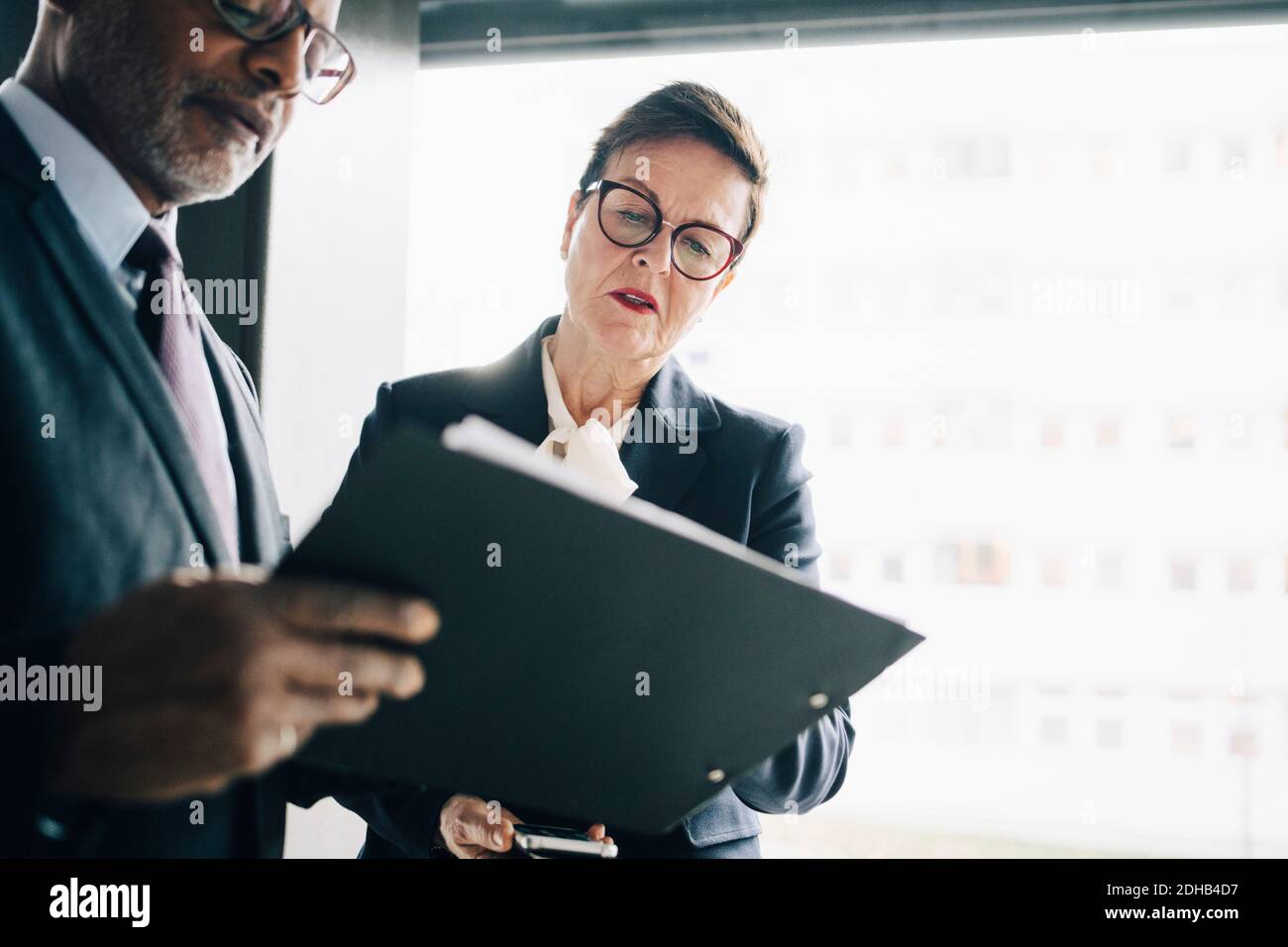 Senior professional discussing strategy with colleague at workplace Stock Photo