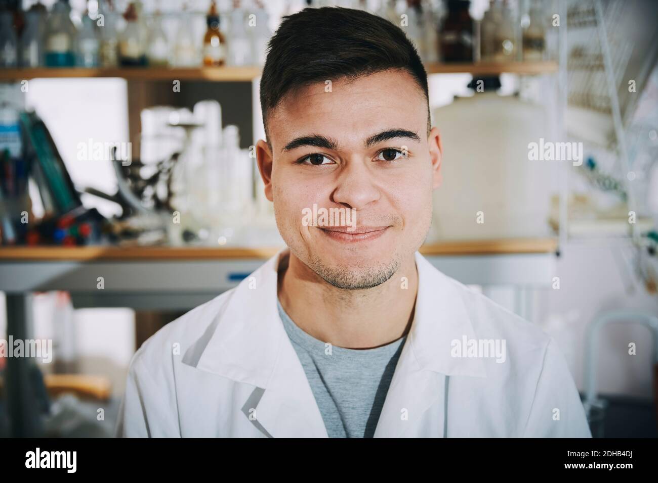 Portrait of confident young male chemistry student standing in college laboratory Stock Photo