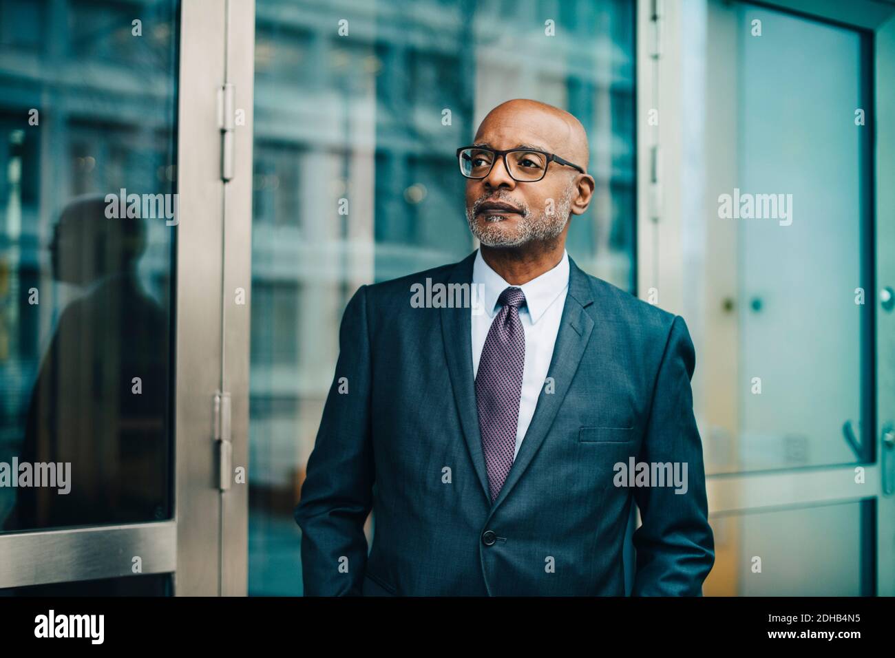 Confident thoughtful businessman wearing suit looking away at office Stock Photo