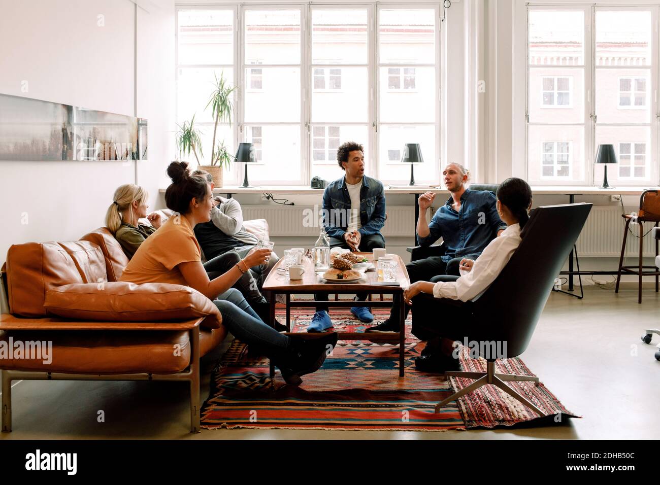 Creative male and female business colleagues talking during break in office Stock Photo