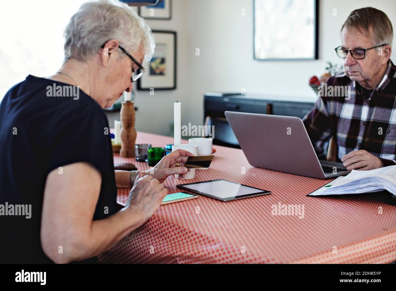 Senior couple using technologies while sitting at dining table Stock Photo