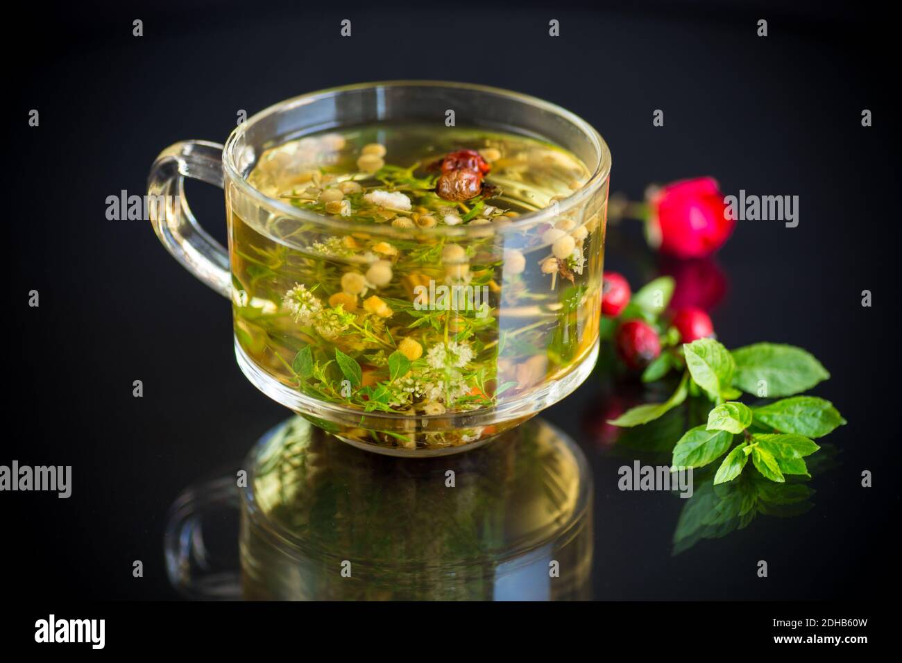hot herbal tea from various herbs in glass cup isolated on black ...