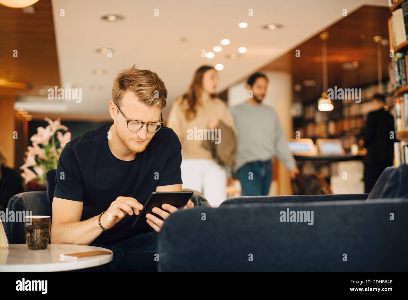 Mid adult man using digital tablet while sitting in restaurant during weekend Stock Photo