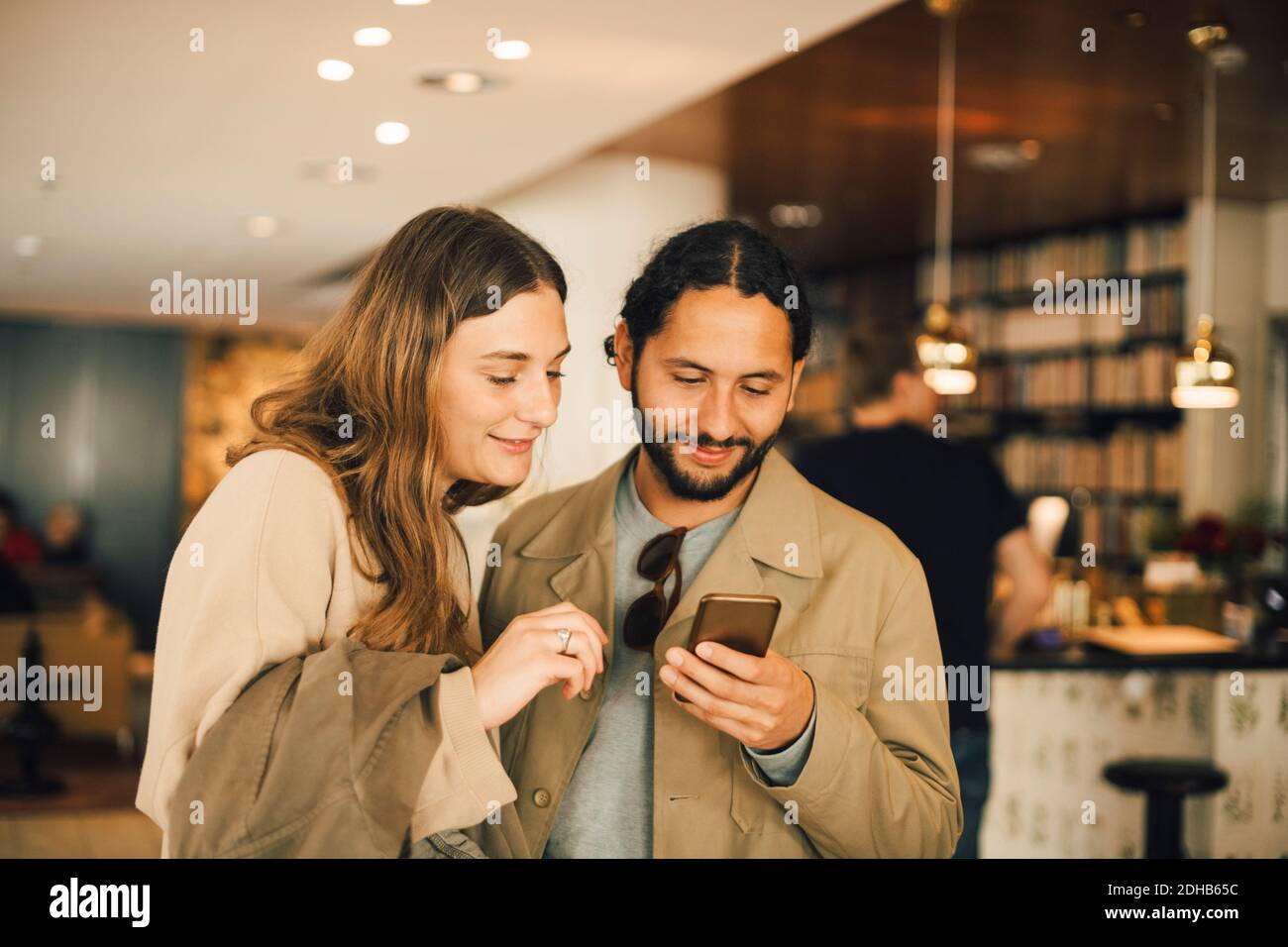 Couple using smart phone while standing in hotel Stock Photo