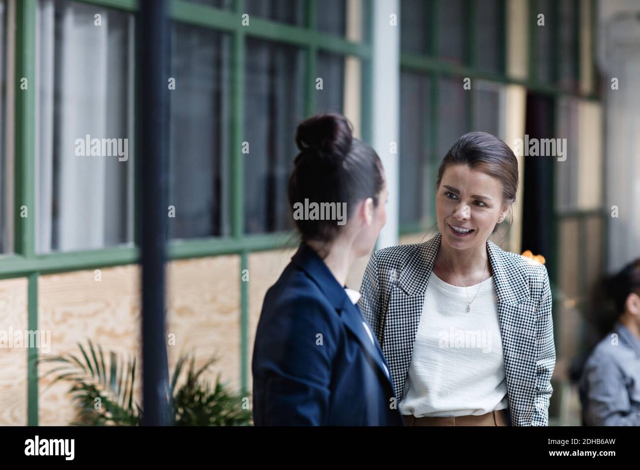 Businesswomen talking while standing at office Stock Photo