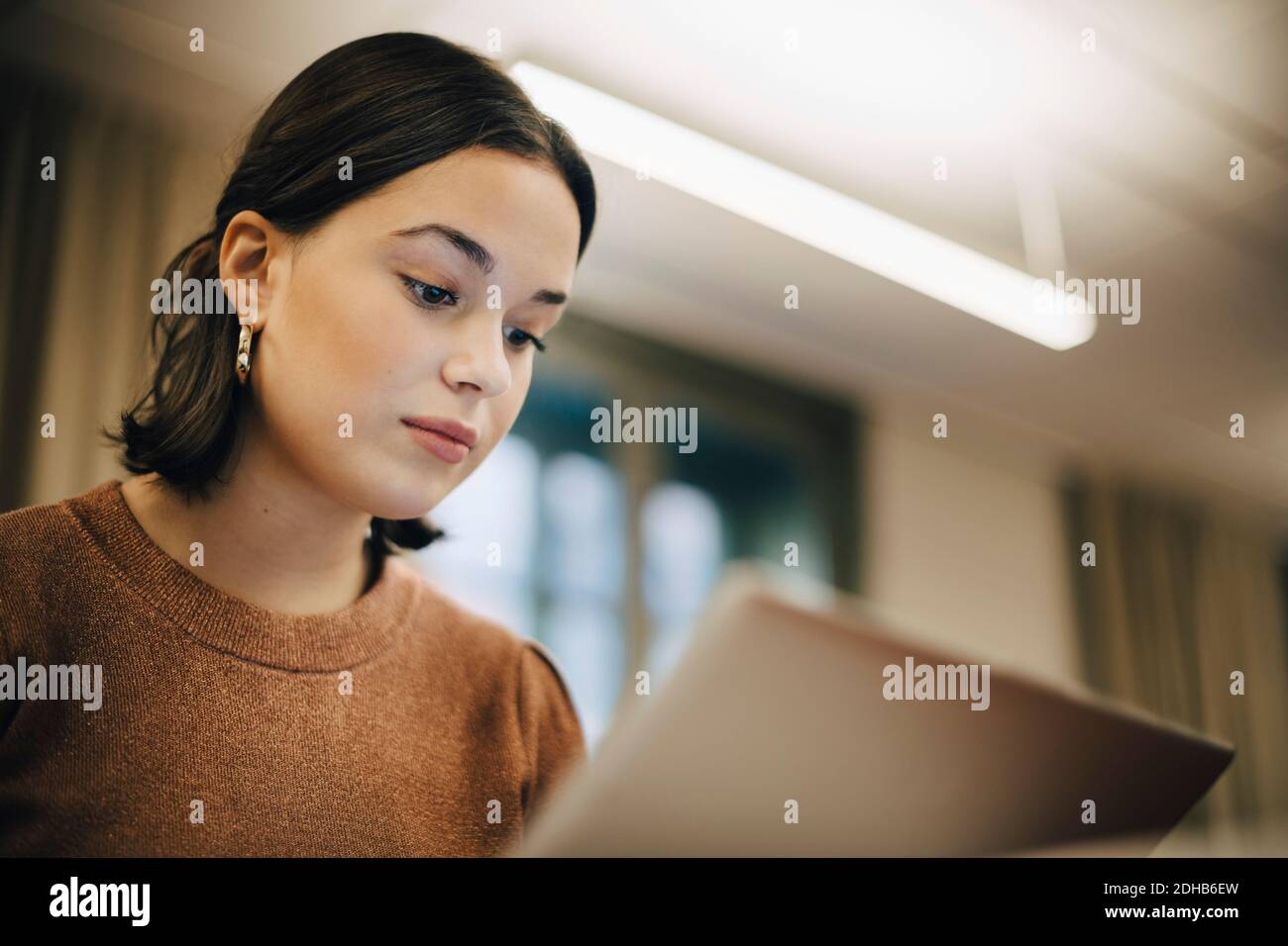 Low angle view of teenage girl using laptop in classroom Stock Photo