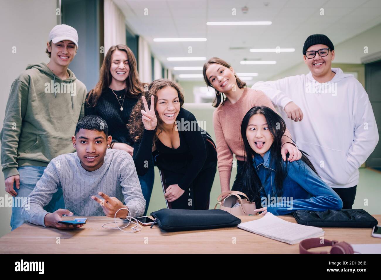Portrait of teenage classmates making faces at desk in classroom Stock Photo