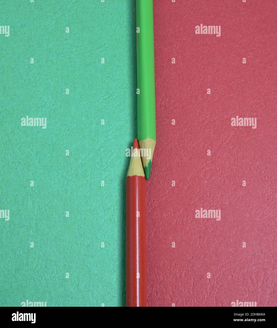 Two colored pencils split a picture in half in two different colors