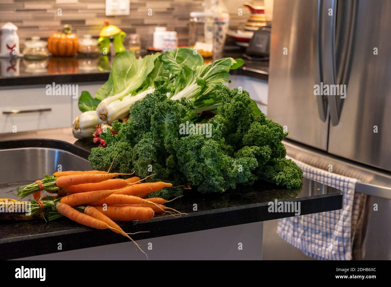 Vegetables from the bazaar lie on a marble black table in the kitchen Stock Photo