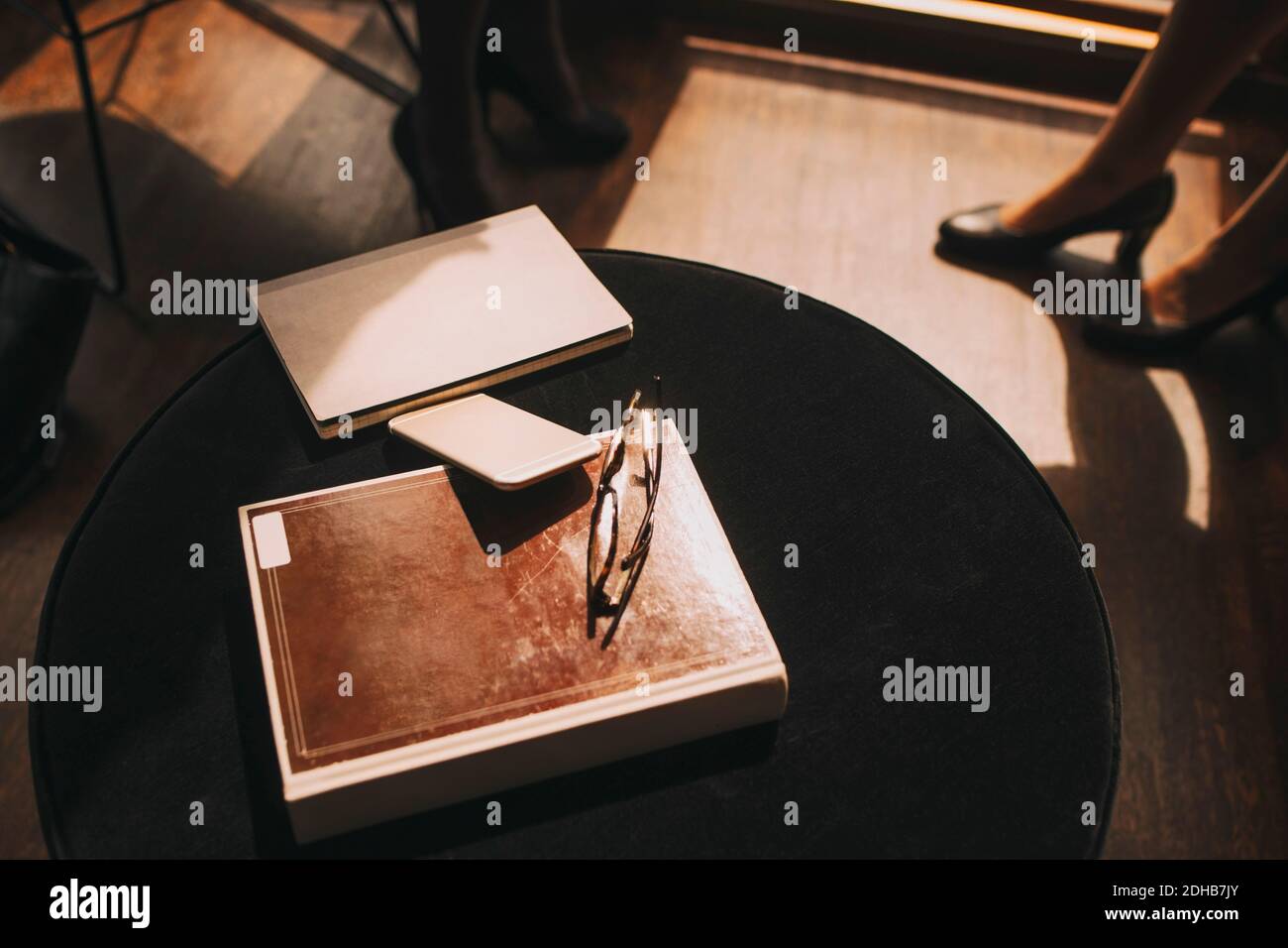 High angle view of diary with mobile phone and eyeglasses at table in office Stock Photo