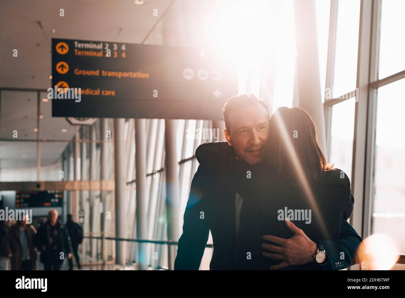 Business couple embracing in airport terminal Stock Photo - Alamy
