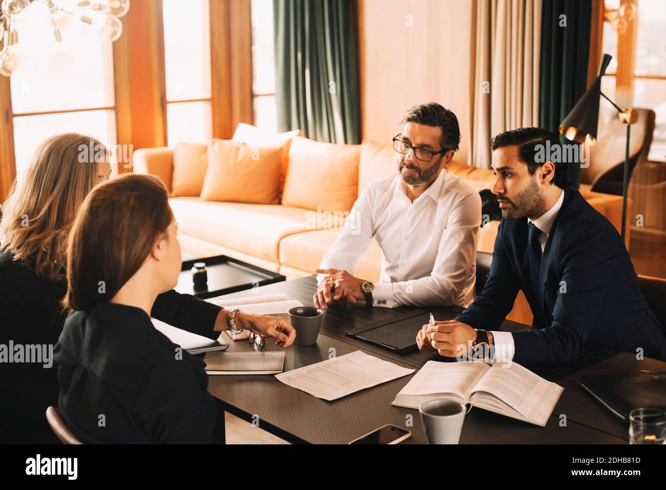 Male and female legal coworkers planning in meeting at board room Stock