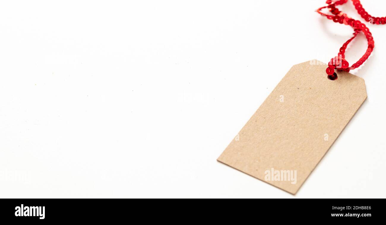 Blank brown carton paper gift tag, Cardboard label isolated on white  background. Kraft recycle price card with red shiny ribbon, template, copy  space Stock Photo - Alamy
