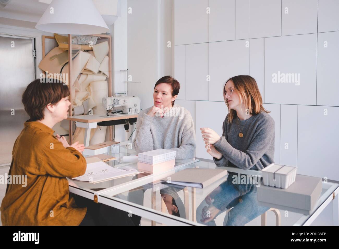 Female design professionals having discussion at desk in workshop Stock Photo