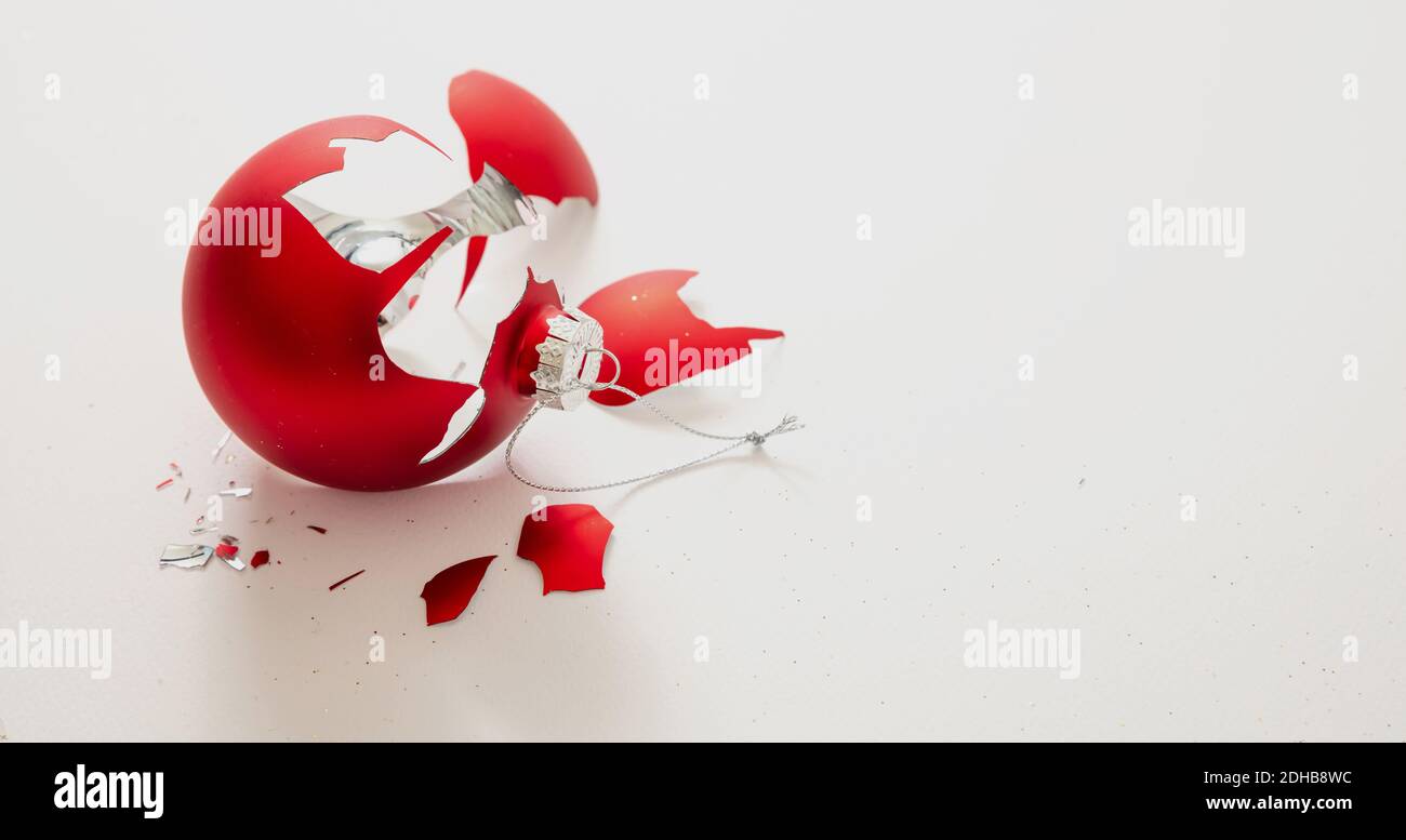 Christmas ball broken isolated on white background, closeup view. Red xmas bauble crashed in pieces. Holiday accident, fragility, anger concept Stock Photo