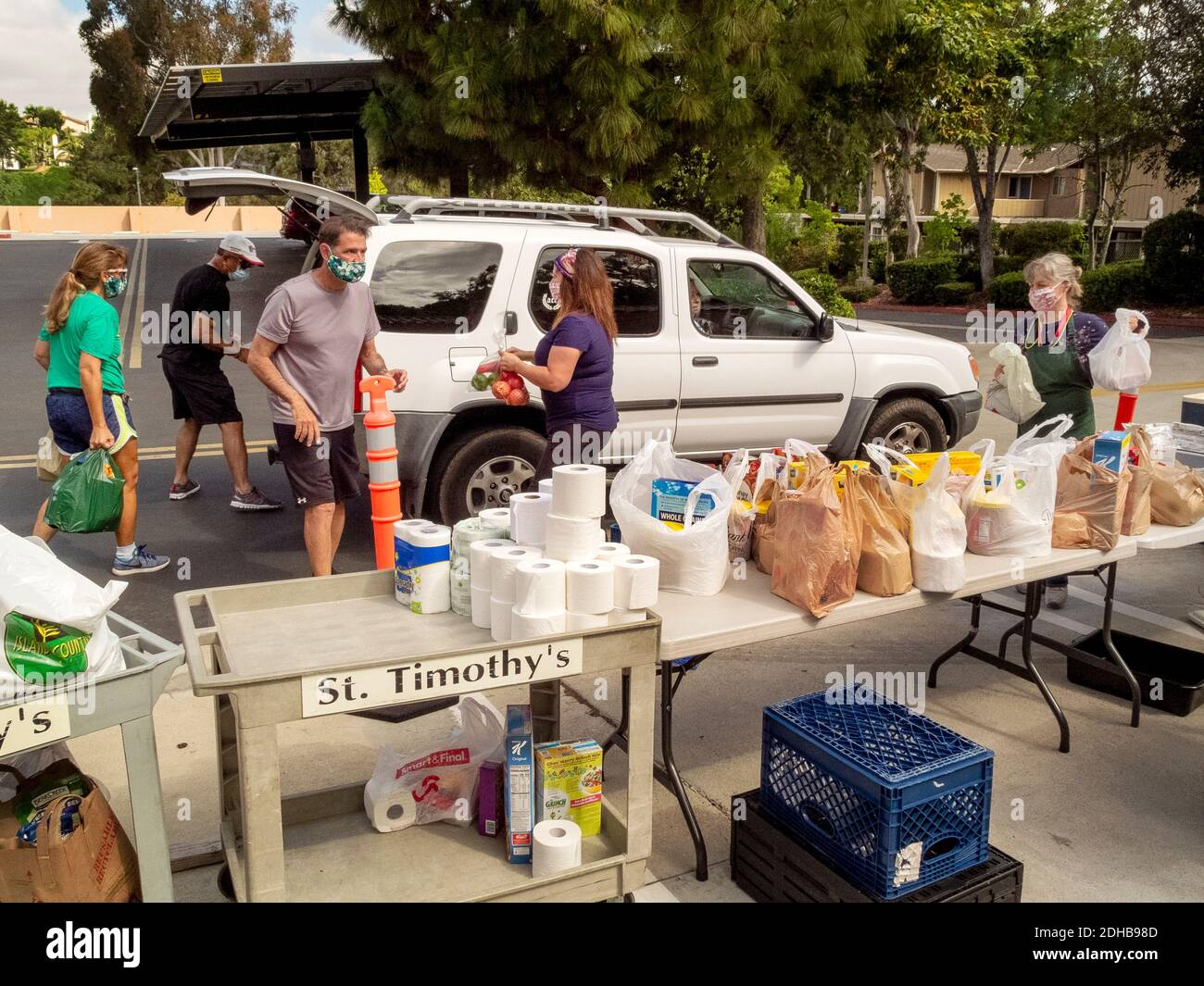 A charity food pantry at a Southern California Catholic church supplies food to needy people using drive through distribution. Note masks due to the coronavirus pandemic. Stock Photo