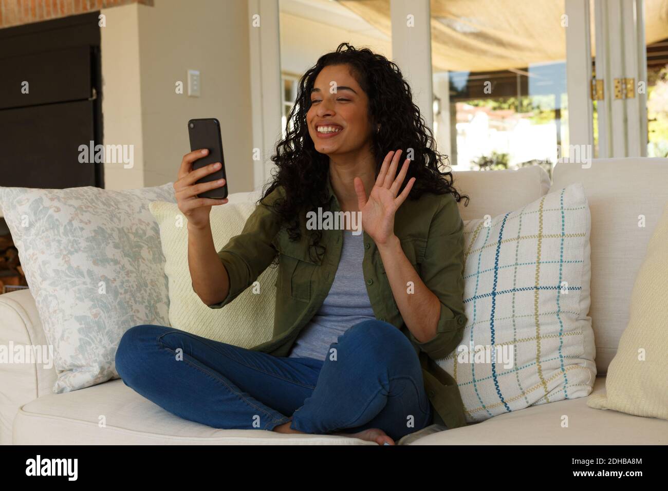 Mixed race woman having video chat on smartphone waving Stock Photo