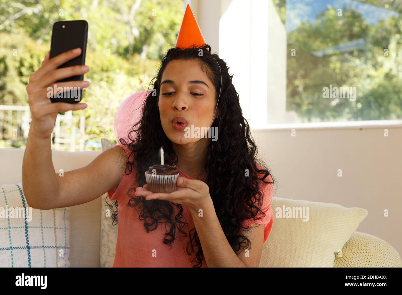 Mixed race woman celebrating birthday having video chat on smartphone Stock Photo
