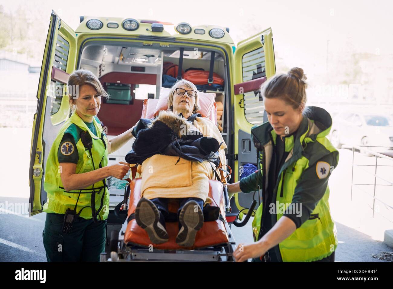 Female paramedics pulling down patient on hospital gurney Stock Photo