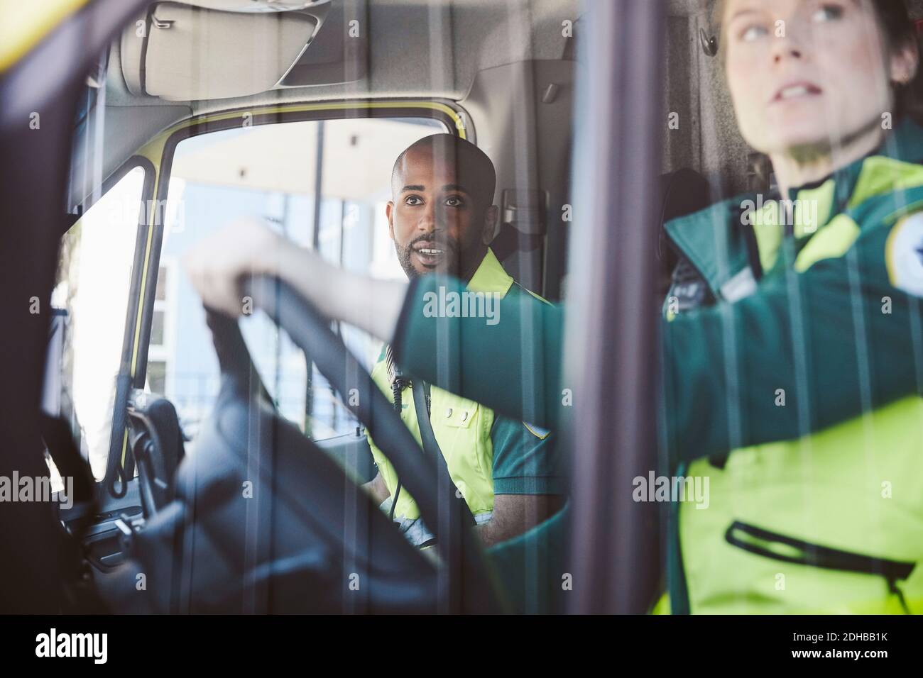 Male and female paramedics looking from ambulance window Stock Photo