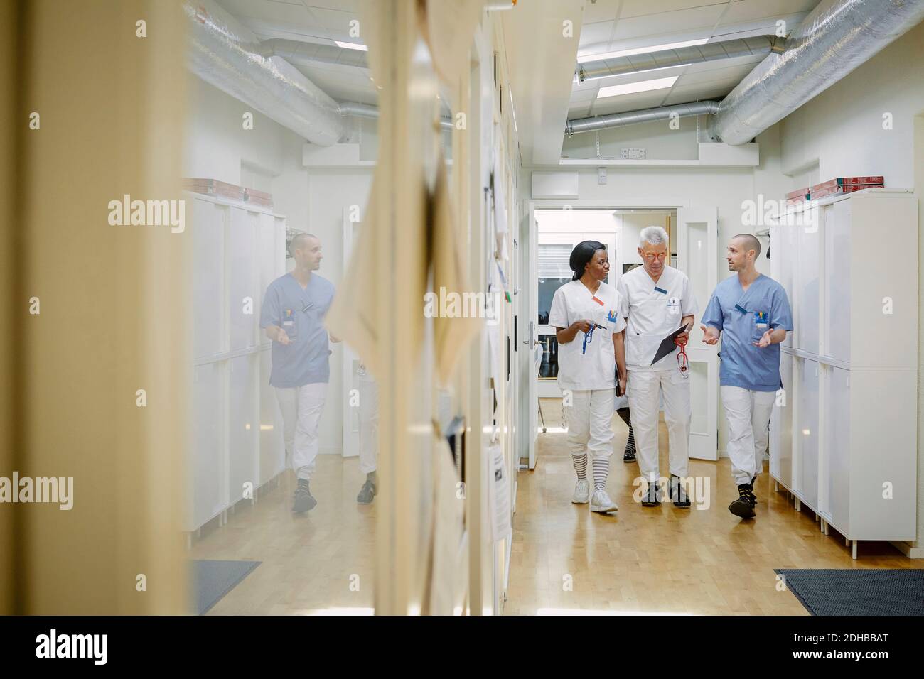 Full length of medical team discussing while walking together in ...