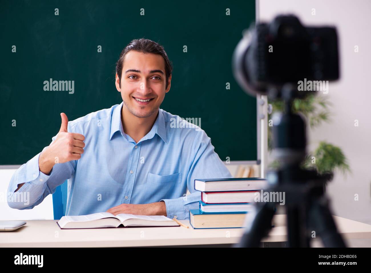 Young handsome teacher recording video for his blog Stock Photo
