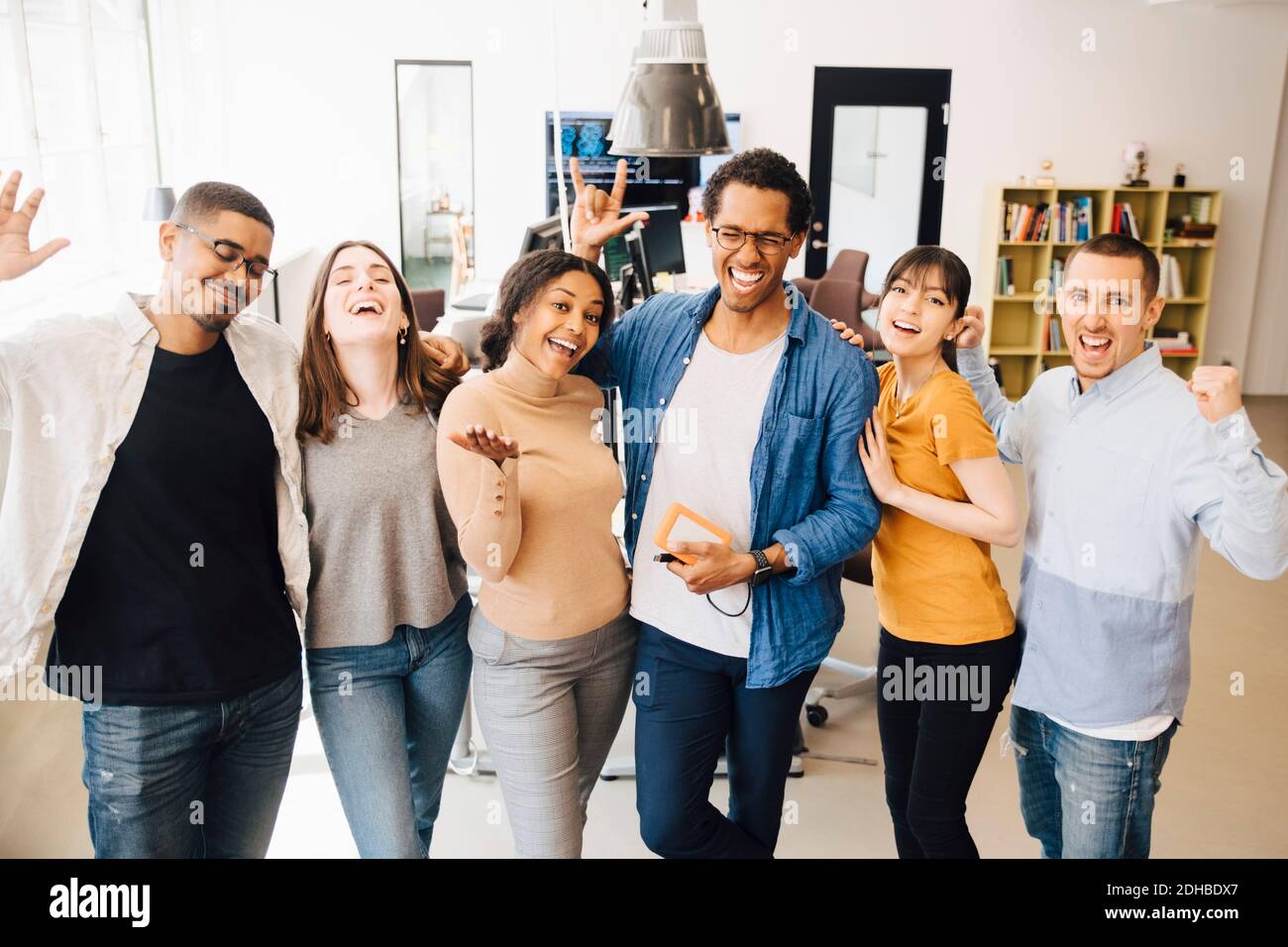 Cheerful computer programmers gesturing while standing in creative office Stock Photo