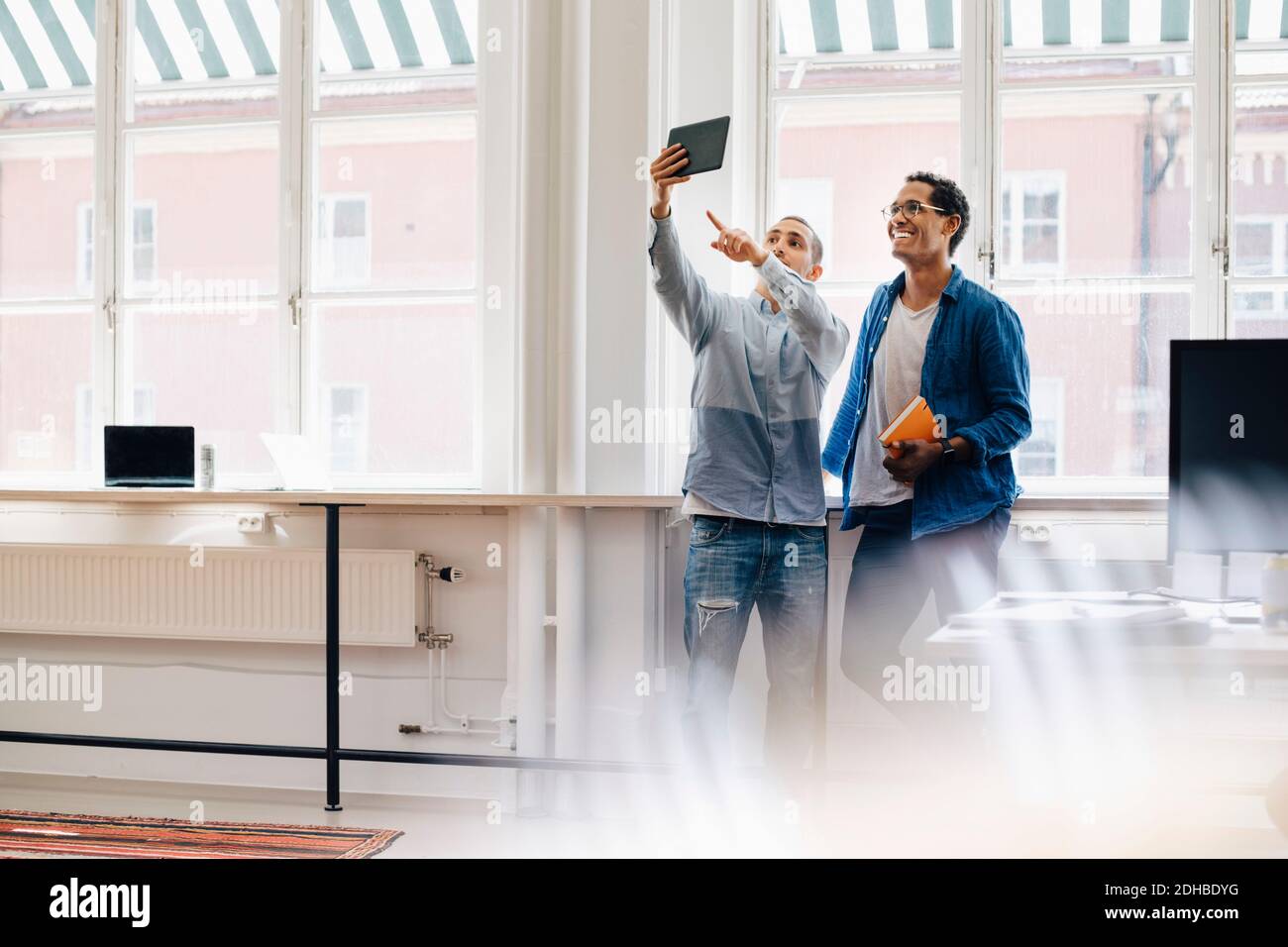 Male computer hackers taking selfie while standing in office Stock Photo