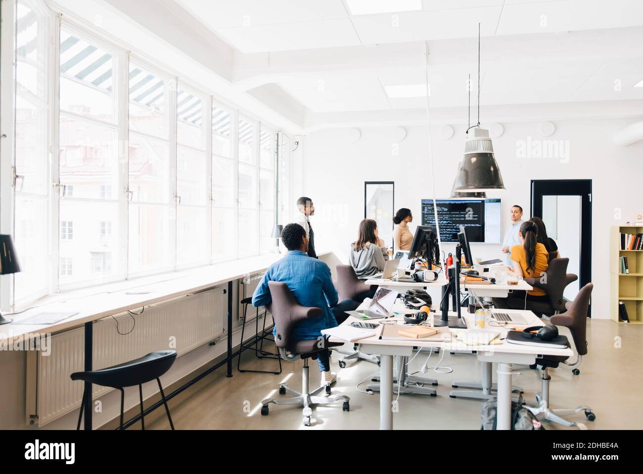Computer programmers discussing over code during meeting in creative office Stock Photo