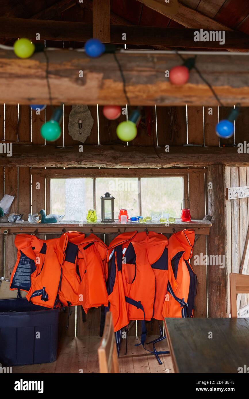 Life jackets hanging on wood in cabin Stock Photo