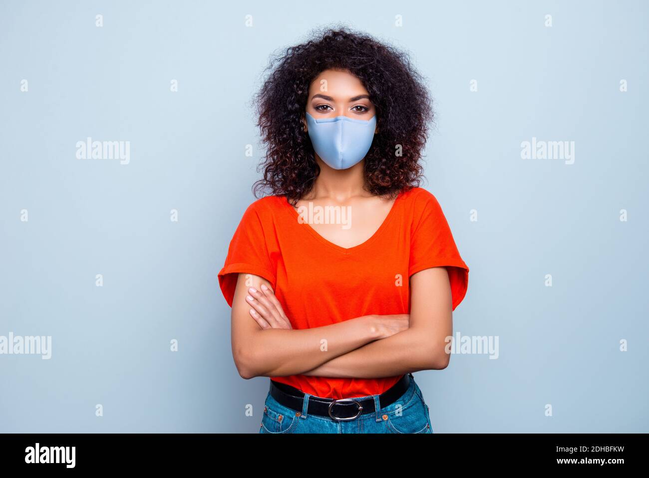 Portrait of pretty content wavy-haired girl wearing safety textile mask stop mers cov folded arms isolated on grey color background Stock Photo